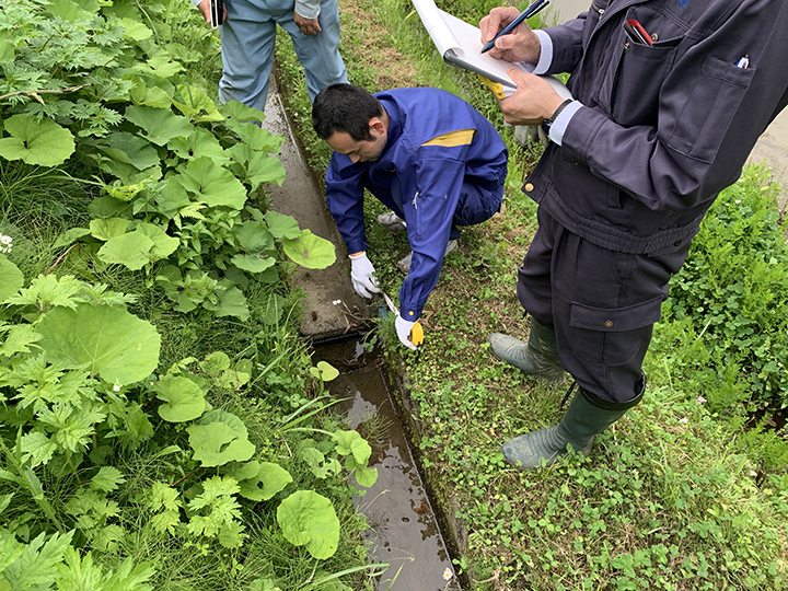 設置条件の確認：現地で水路の寸法を測る様子